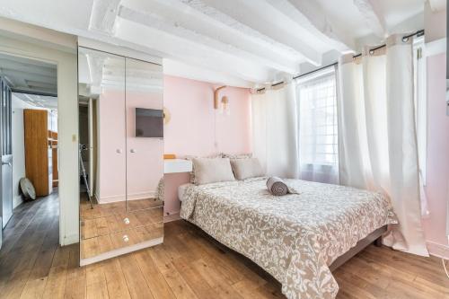 une chambre avec un lit et une grande fenêtre dans l'établissement Charming Flat Montorgueil, à Paris