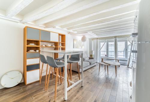 une cuisine et une salle à manger avec une table et des chaises dans l'établissement Charming Flat Montorgueil, à Paris