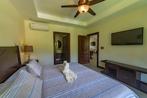 a bedroom with a bed with a towel on it at Villa Arrecife By Vacation Pura Vida in Bejuco