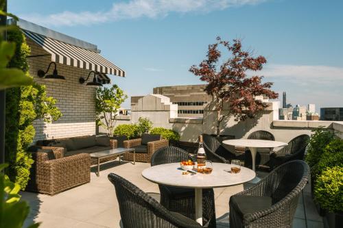 a patio with tables and chairs on a roof at Sonder at One Platt in New York