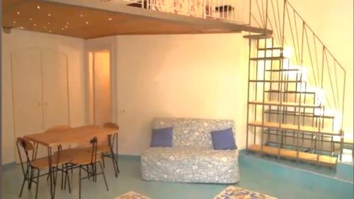 a room with a table and a bed and a staircase at PALAZZO PELLEGRINO vietri in Vietri sul Mare