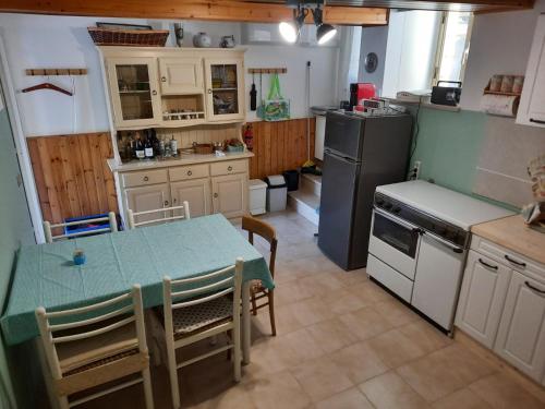 a kitchen with a table and a kitchen with a refrigerator at Ferienhaus in Frontone in Frontone