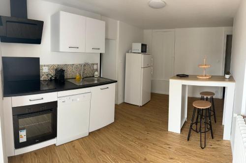 une cuisine avec des armoires blanches et un comptoir dans l'établissement Charmante maison au calme, à Chauvigny