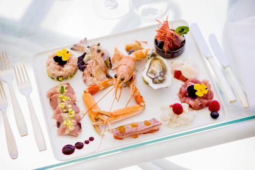 a white plate of food on a table at Hotel Caravelle Thalasso & Wellness in Diano Marina