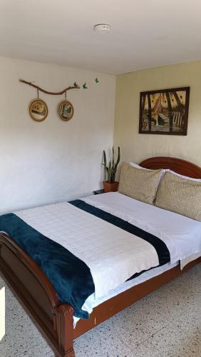 a bedroom with a large bed with a wooden headboard at Hotel Marrokos Aeropuerto José María Córdova in Rionegro