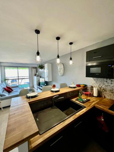 une cuisine avec un comptoir et un salon dans l'établissement Charmant & Calme 3P climatisé 2 chambres Vue panoramique Parking privatif en sous sol, à Nice