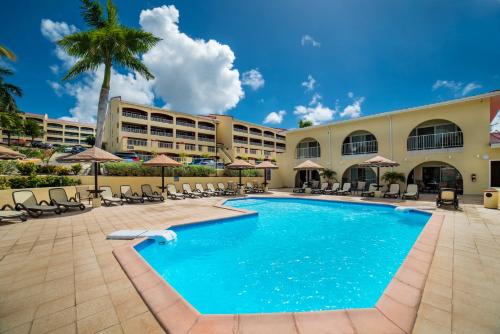 una piscina en el complejo con sillas y sombrillas en Simpson Bay Resort Marina & Spa en Simpson Bay