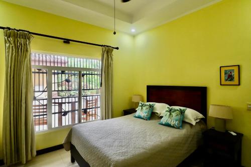 a bedroom with a bed and a large window at Villa Sendero By Vacationpuravida in Bejuco