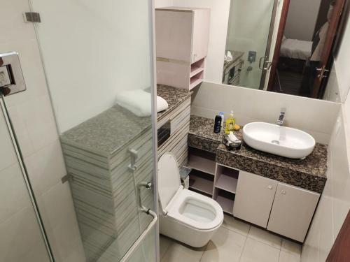 La salle de bains est pourvue de toilettes et d'un lavabo. dans l'établissement One Bed Apartment In GoldCrest Mall And Residency, à Lahore