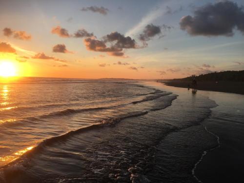 a sunset on a beach with the ocean at The Wavefront Beachfront Condo In Bejuco in Bejuco