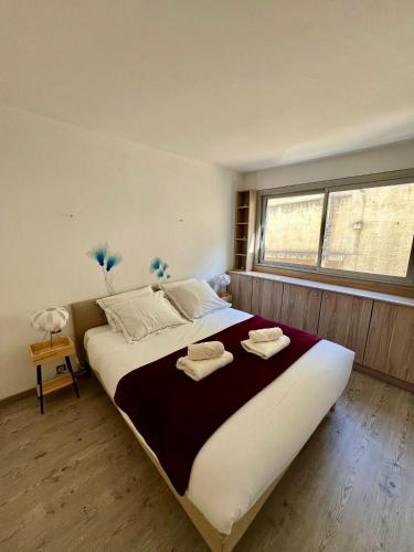 une chambre avec un grand lit avec des serviettes dessus dans l'établissement Charmant & Calme 3P climatisé 2 chambres Vue panoramique Parking privatif en sous sol, à Nice