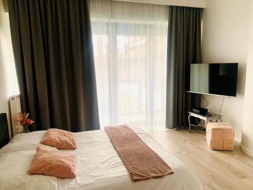 a bedroom with a bed and a large window at Hanza Tower De Lux apartament in Szczecin