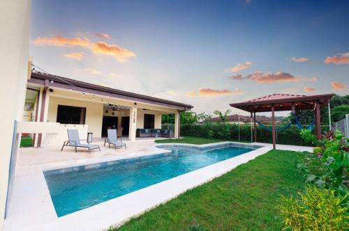 a swimming pool in the backyard of a house at Villa Alegra De Vivir By Vacation Pura Vida in Esterillos