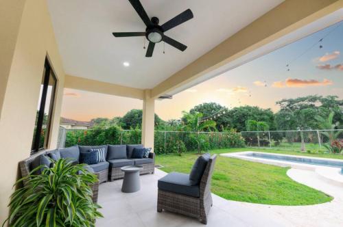a patio with couches and a ceiling fan at Villa Alegra De Vivir By Vacation Pura Vida in Esterillos