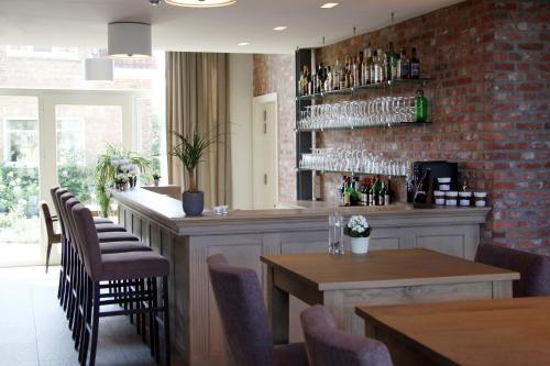 a restaurant with a bar with glasses on the wall at HuysHoeve in Knokke-Heist