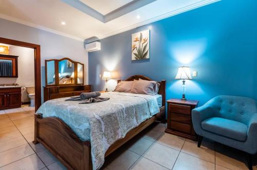 a bedroom with a bed and a blue wall at Villa Brisa Del Mar By Vacation Pura Vida in Esterillos