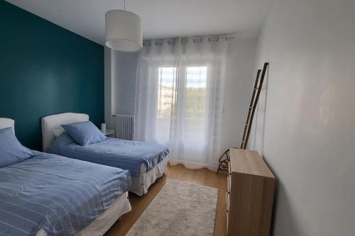 une chambre avec deux lits et une fenêtre dans l'établissement Appartement spacieux et moderne, à Tours