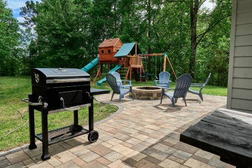 a grill on a patio next to a playground at Private Peaceful House near Lake Lure Chimney Rock in Rutherfordton