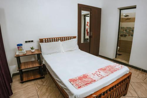 a large bed in a room with a bathroom at Venitia Homestay in Alleppey
