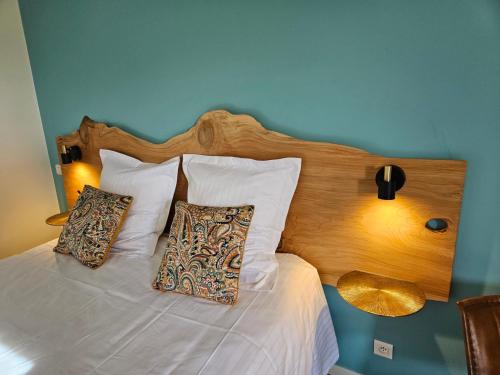 - un lit avec une tête de lit en bois et 2 oreillers dans l'établissement Domaine de Keryargon, Chambres d'hôtes B&B et Location de Vacances, à Belz