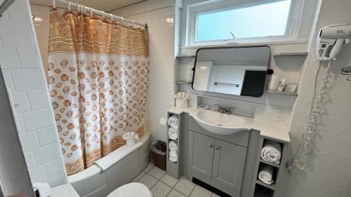 a bathroom with a sink and a shower curtain at Sea Gull Motel in Wildwood