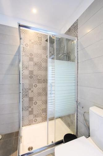 a bathroom with a shower with a glass door at Sofias Retreat Nissaki in Katávolos