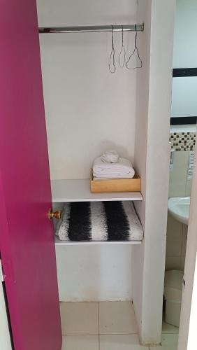 a bathroom with a sink and a shelf with a towel at Hotel Marrokos Aeropuerto José María Córdova in Rionegro