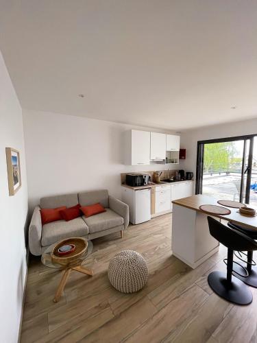 un salon avec un canapé et une table dans l'établissement appartements guesthouse1 et guesthouse2 sword beach, à Colleville-Montgomery