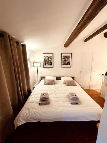 une chambre avec un grand lit blanc avec des serviettes dessus dans l'établissement Mazarin Suite Centre ville historique proche cours Mirabeau, à Aix-en-Provence