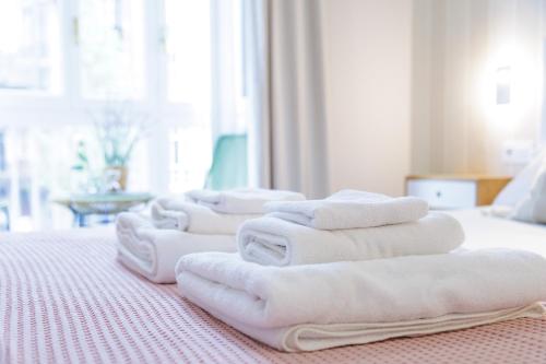 eine Reihe weißer Handtücher auf einem Bett in der Unterkunft Apartamento Pagasarri, Bilbaohost in Bilbao