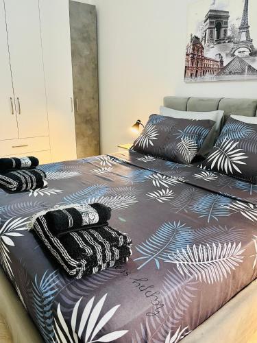 1 Schlafzimmer mit 2 Betten und schwarzen und weißen Decken in der Unterkunft ALBI’S Apartment in Tirana
