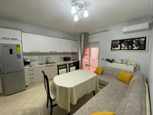 cocina con sofá y mesa en Olive Tree Apartment, en Sarandë