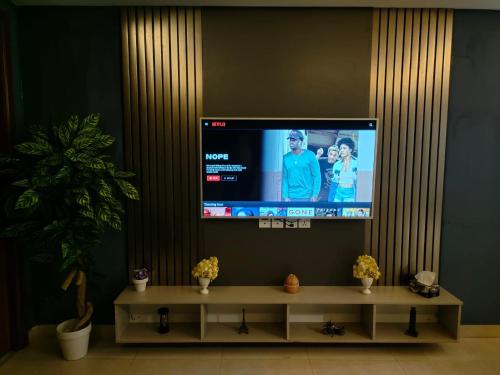 een flatscreen-tv in een woonkamer met een tafel bij One bed appartment in GOLDCrest DHA Lahore in Lahore