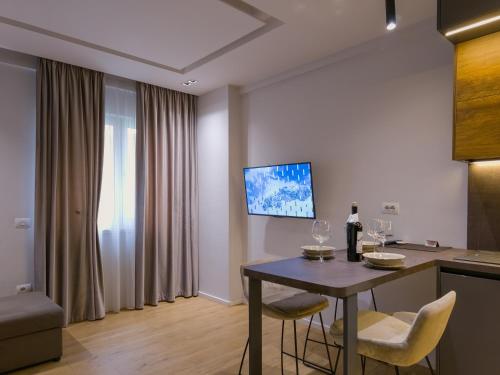 - un salon avec une table, des chaises et une télévision dans l'établissement PIN Apartments, à Tirana