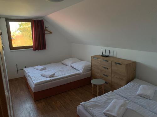 - une chambre avec 2 lits, une commode et une fenêtre dans l'établissement V srdci Moravy, à Velké Bílovice