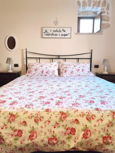 a bed with a floral bedspread and pillows on it at Il Bagolaro Casa Vacanze in Sulmona