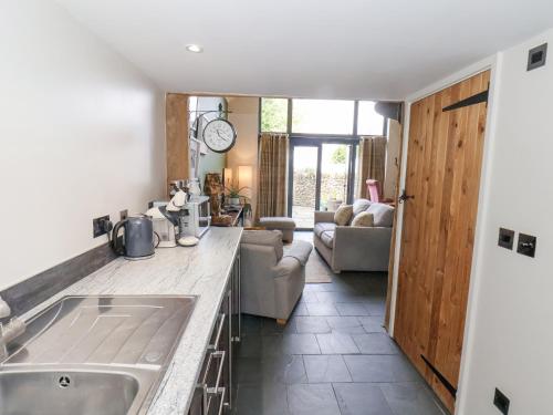 a kitchen with a sink and a living room at The Nail Shed in Scarborough
