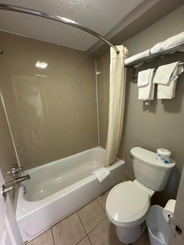 a bathroom with a toilet and a tub and a sink at Econo Lodge Galveston Seawall in Galveston