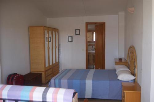 Dormitorio pequeño con 2 camas y armario en Apartamentos Marineu Voramar, en Alcossebre