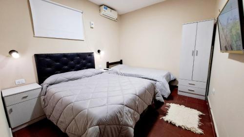 1 dormitorio con 2 camas y pared blanca en Departamento Capital en San Fernando del Valle de Catamarca