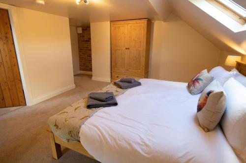 a bedroom with a large white bed with towels on it at The Granary in Martin
