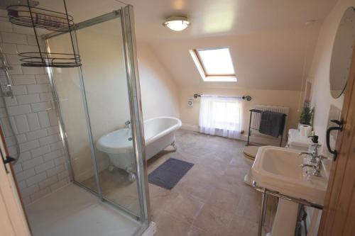 a bathroom with a shower and a tub and a sink at The Granary in Martin