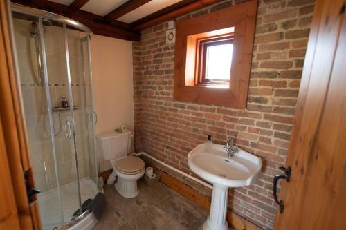 a bathroom with a sink and a toilet and a shower at The Granary in Martin