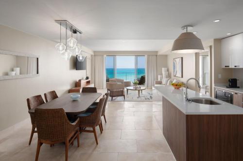 Saint George的住宿－The Residences at The St. Regis Bermuda，厨房、带桌子的客厅和用餐室