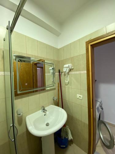 a bathroom with a sink and a mirror at Olive Tree Apartment in Sarandë