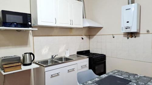a small kitchen with a sink and a microwave at Departamento Capital in San Fernando del Valle de Catamarca