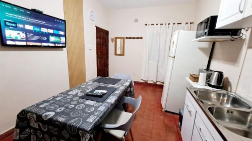 Habitación con mesa y cocina con fregadero en Departamento Capital en San Fernando del Valle de Catamarca