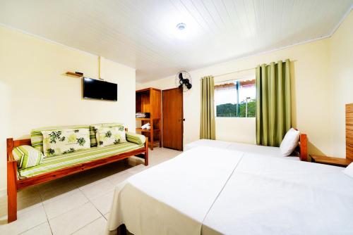 Habitación de hotel con cama y sofá en Recanto Julubi Atibaia en Atibaia