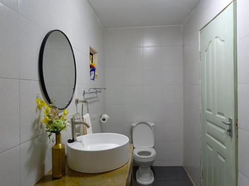 a bathroom with a sink and a mirror and a toilet at Kwetu Home - Sagana in Sagana