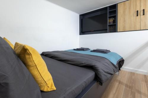 a bedroom with a couch with a tv on the wall at Sunflower Apartment in Belgrade